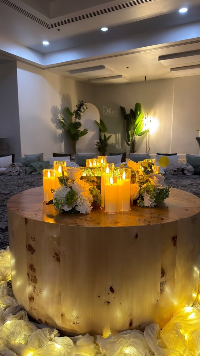 Fireside Chat ambiance with candles and flowers on a round wooden table