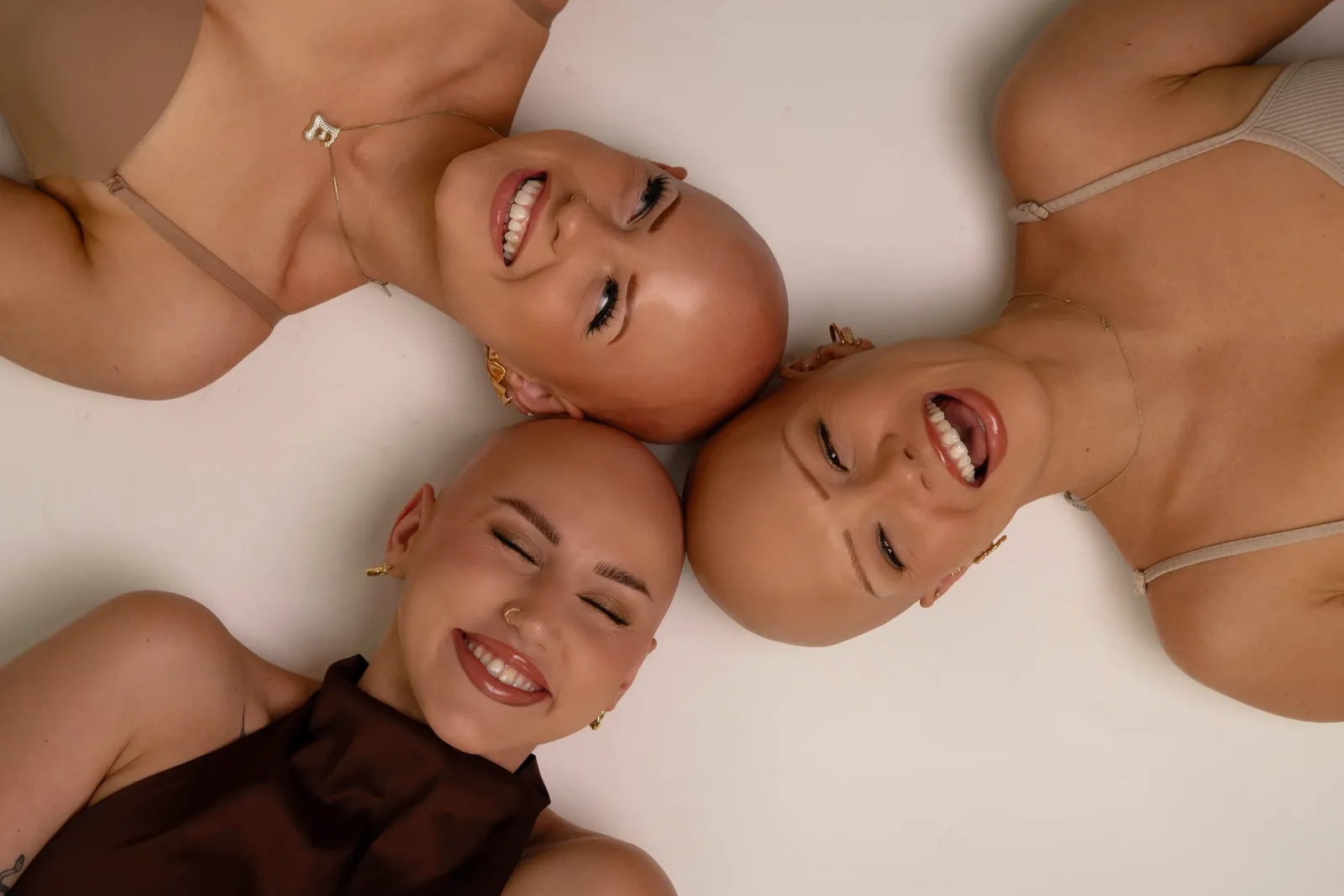 Emmy, Alex, and Christie laying together for Beauty Beyond Barriers